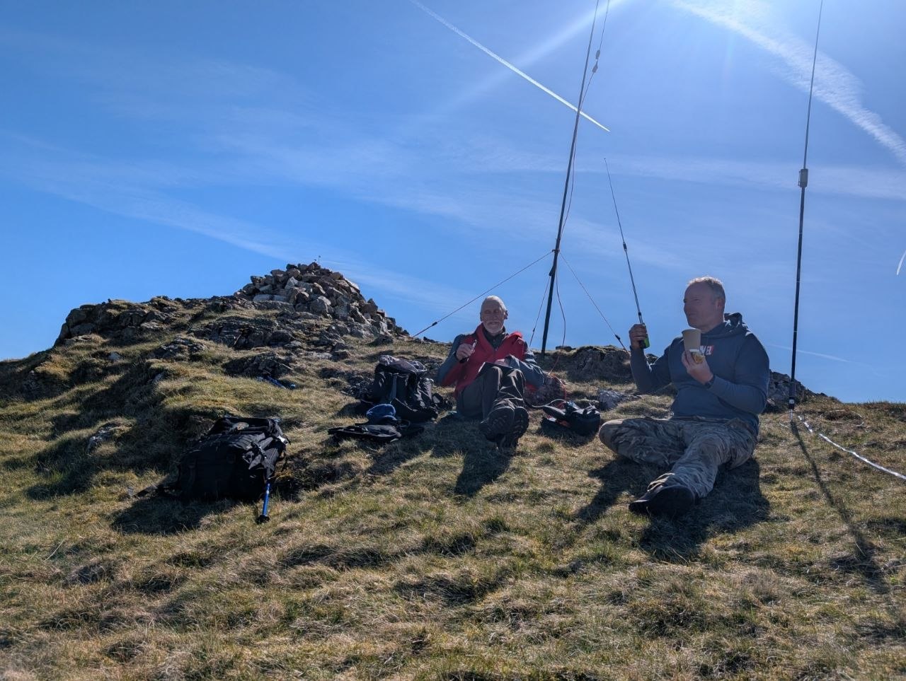 Richard and Dean sitting by the summit cairn with portable antennas