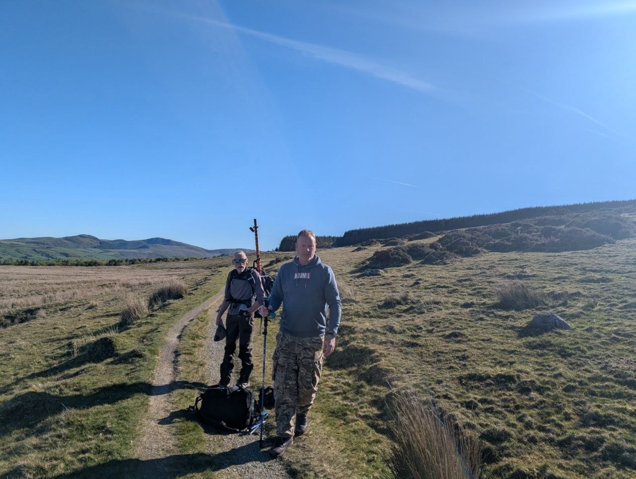 Richard and Dean walking a fell path with packs and poles